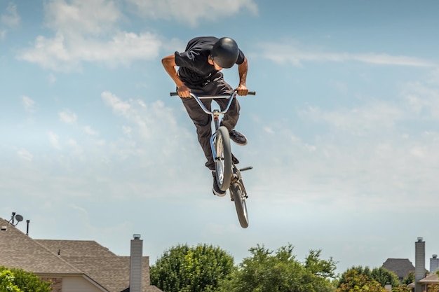 空に向かってジャンプする自転車に乗った男の低角度の写真