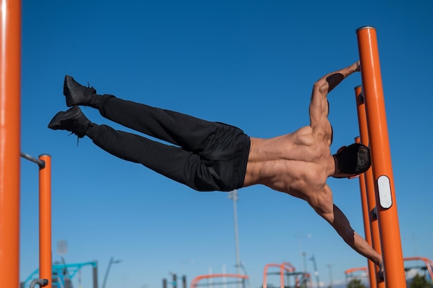 晴れた空を背景に運動している男性の低角度の写真