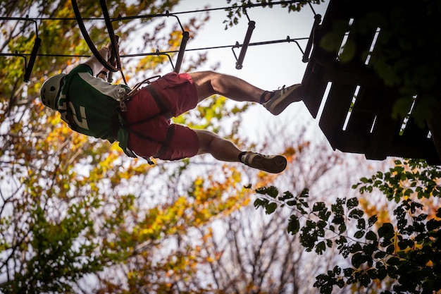 Foto vista ad angolo basso di un uomo appeso agli alberi nella foresta