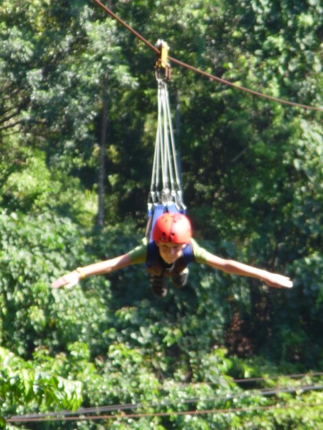 Low angle view of man hanging on rope