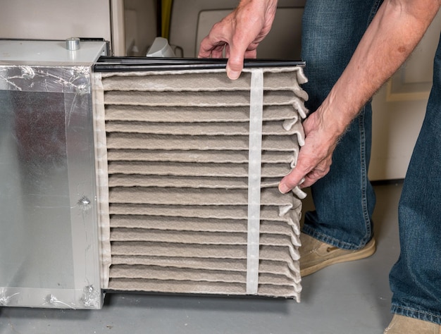 Photo low angle view of man holding air conditioner filter