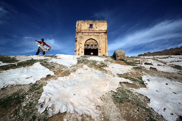 Foto vista ad angolo basso di un uomo che tiene la plastica vicino alla vecchia chiesa in rovina