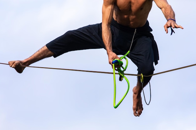 Low angle view of man holding rope against sky