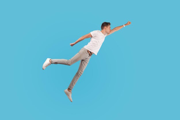 Photo low angle view of man jumping against blue background