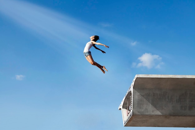 Foto vista a bassa angolazione di un uomo che salta contro il cielo