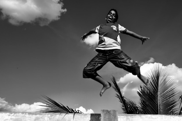 Photo low angle view of man jumping against sky