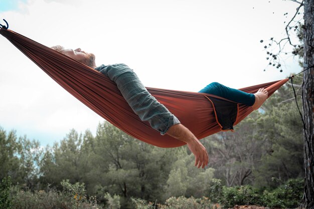 Photo low angle view of man lying on hammock