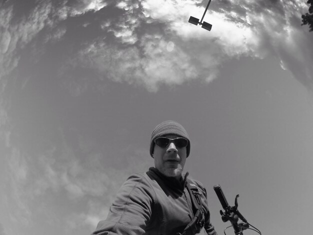 Photo low angle view of man in mid-air against sky