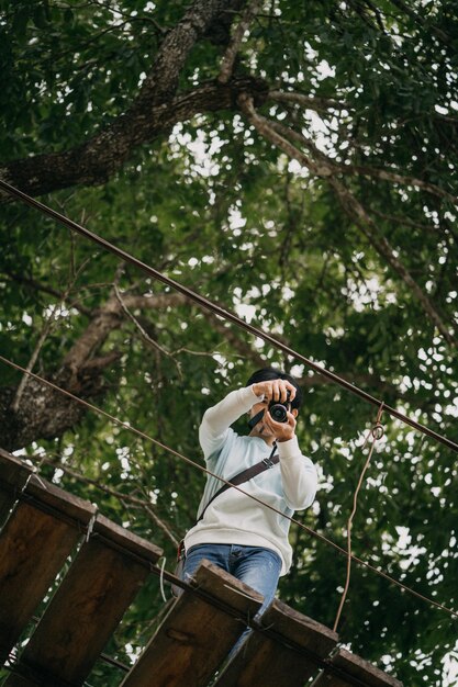 Photo low angle view of man photographing in forest