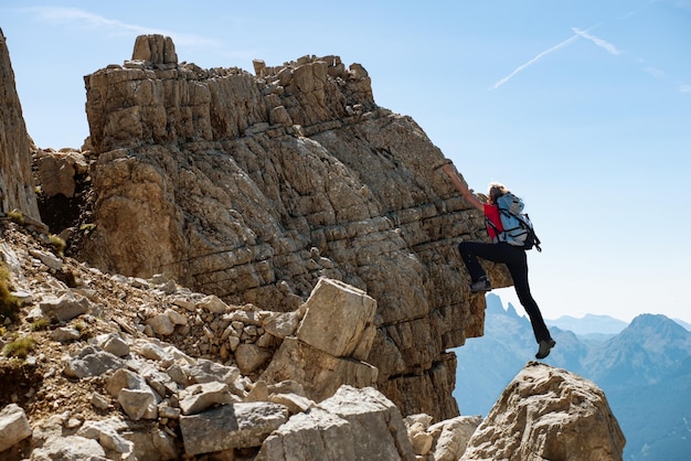 Foto vista a bassa angolazione di un uomo che si arrampica contro il cielo