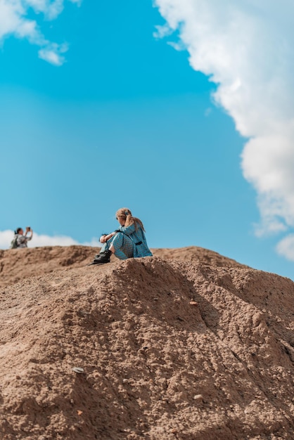 Low angle view of man sitting on rock against sky