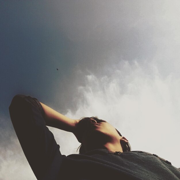 Low angle view of man smoking against sky