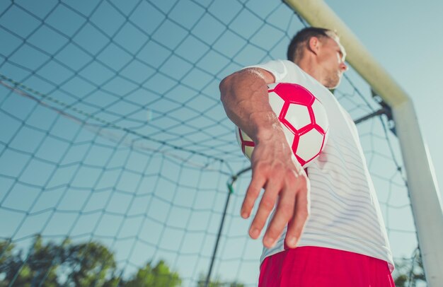 Photo low angle view of man with ball standing by goal post