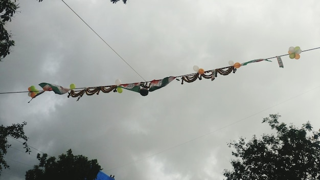 Low angle view of matki hanging against cloudy sky during dahi handi