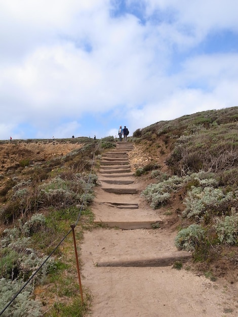 Photo low angle view of men on steps at hill against sky