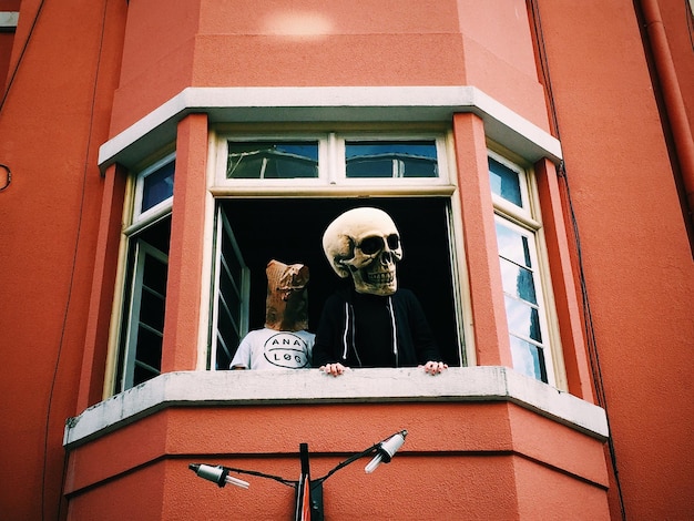 Low angle view of men wearing costumes standing at window