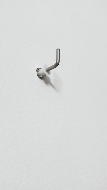 Photo low angle view of metal hook mounted on wall