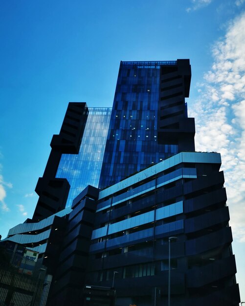 Low angle view of modern building against blue sky