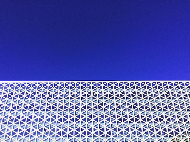 Low angle view of modern building against blue sky