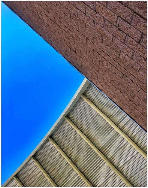 Low angle view of modern building against blue sky