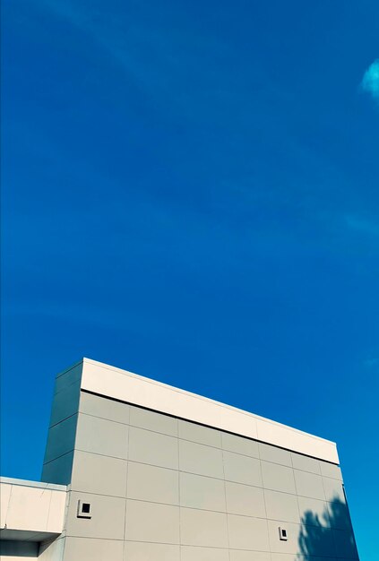 Low angle view of modern building against blue sky