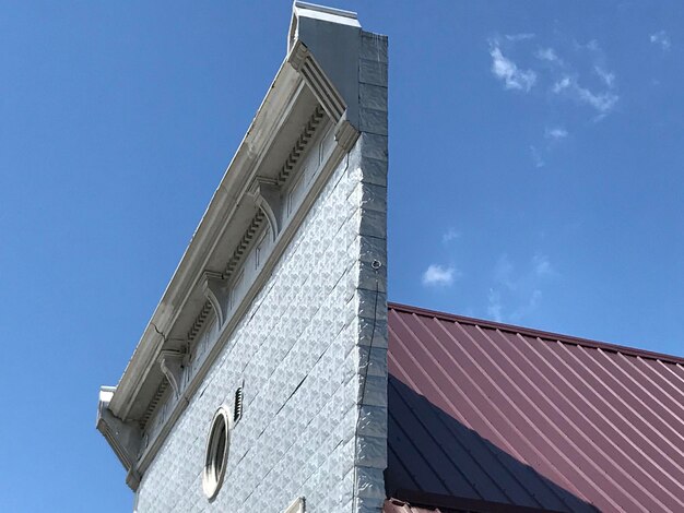 Low angle view of modern building against blue sky