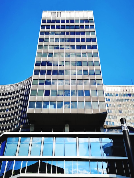 Foto vista a basso angolo di un edificio moderno contro un cielo blu limpido