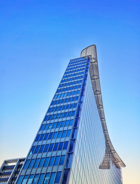 Low angle view of modern building against clear blue sky