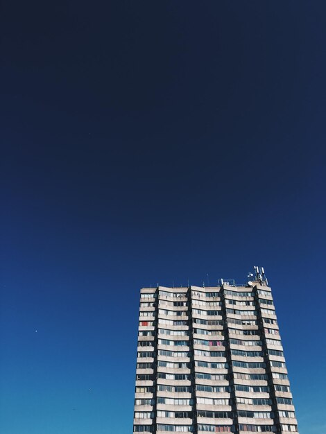 Low angle view of modern building against clear blue sky