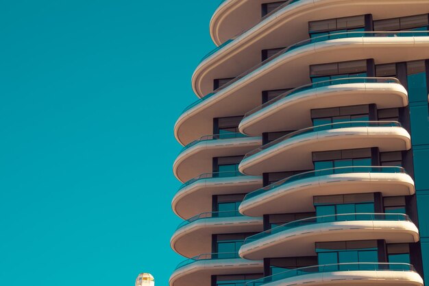 透明なターコイズブルーの空を背景に近代的な建物の低角度の景色