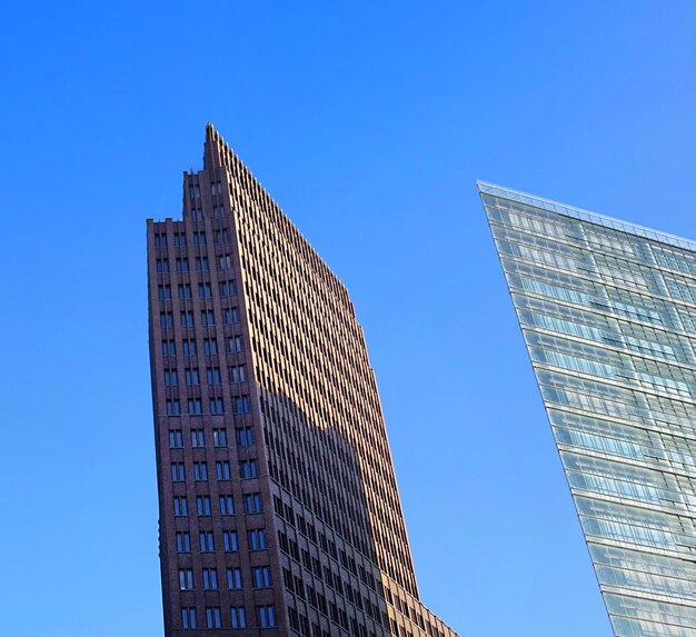 Low angle view of modern buildings against clear blue sky