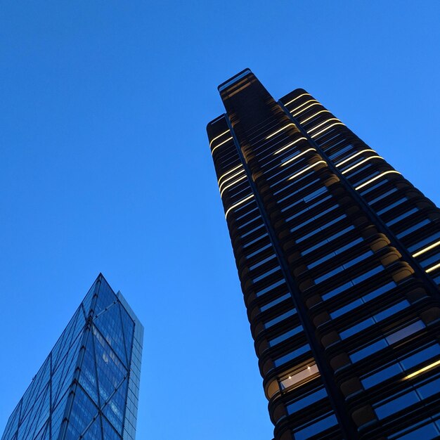 Low angle view of modern buildings against clear blue sky