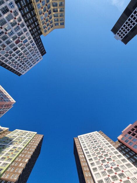 Low angle view of modern buildings against clear blue sky