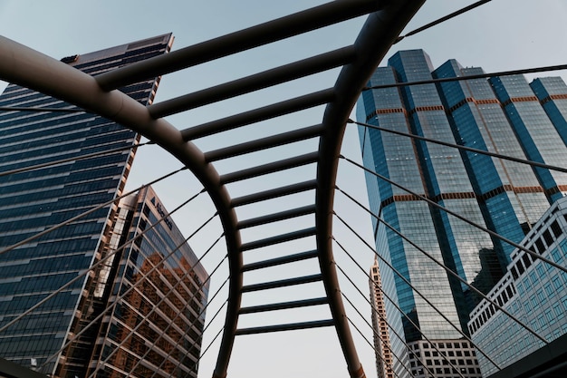 Photo low angle view of modern buildings against sky seen through bridge at sathon district