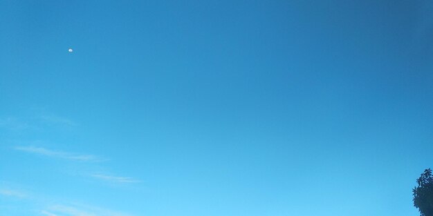 Low angle view of moon against blue sky