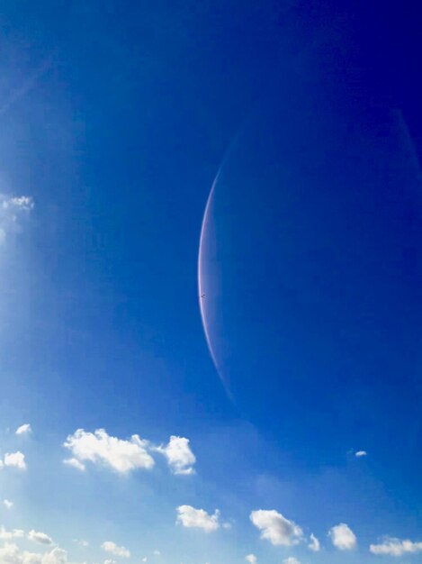 Low angle view of moon against blue sky