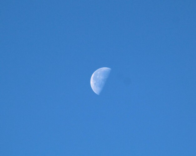 Low angle view of moon against blue sky