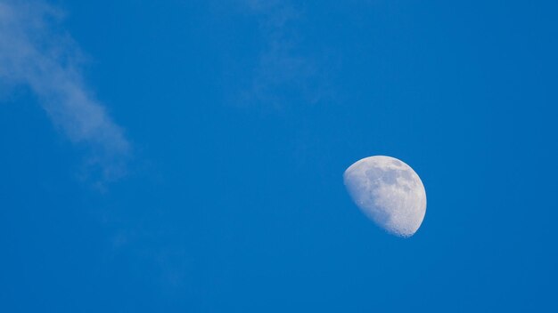 Low angle view of moon against blue sky