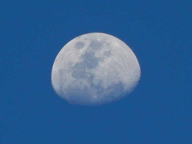 Low angle view of moon against blue sky