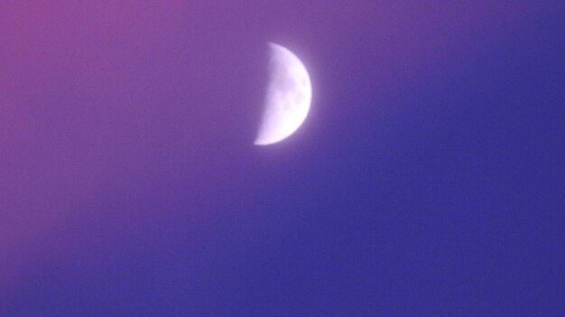 Low angle view of moon against clear blue sky