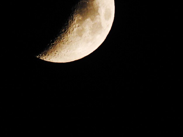 晴れた夜の空に照らされた月を低角度で眺める