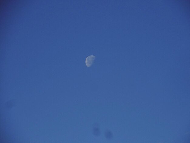 Low angle view of moon in blue sky