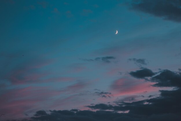 Low angle view of moon in sky at sunset