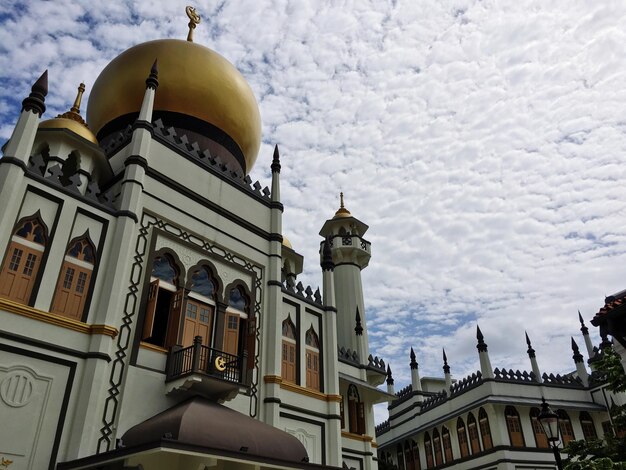 Foto vista a bassa angolazione della moschea contro un cielo nuvoloso