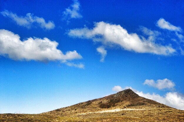 Low angle view of mountain against blue sky