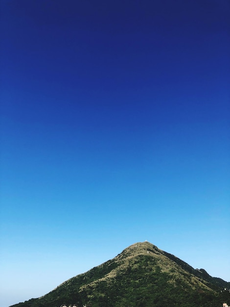 Low angle view of mountain against clear blue sky