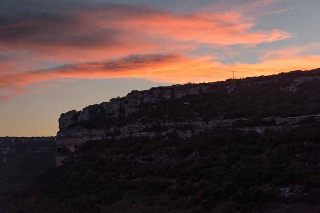 Low angle view of mountain against orange sky