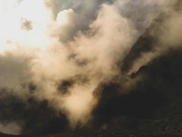 Low angle view of mountains against cloudy sky