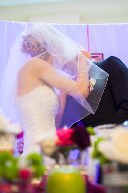 Low angle view of newlywed couple kissing while standing in wedding ceremony