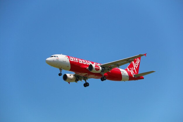 写真 晴れた青い空を背景に飛行する飛行機の低角度の視点